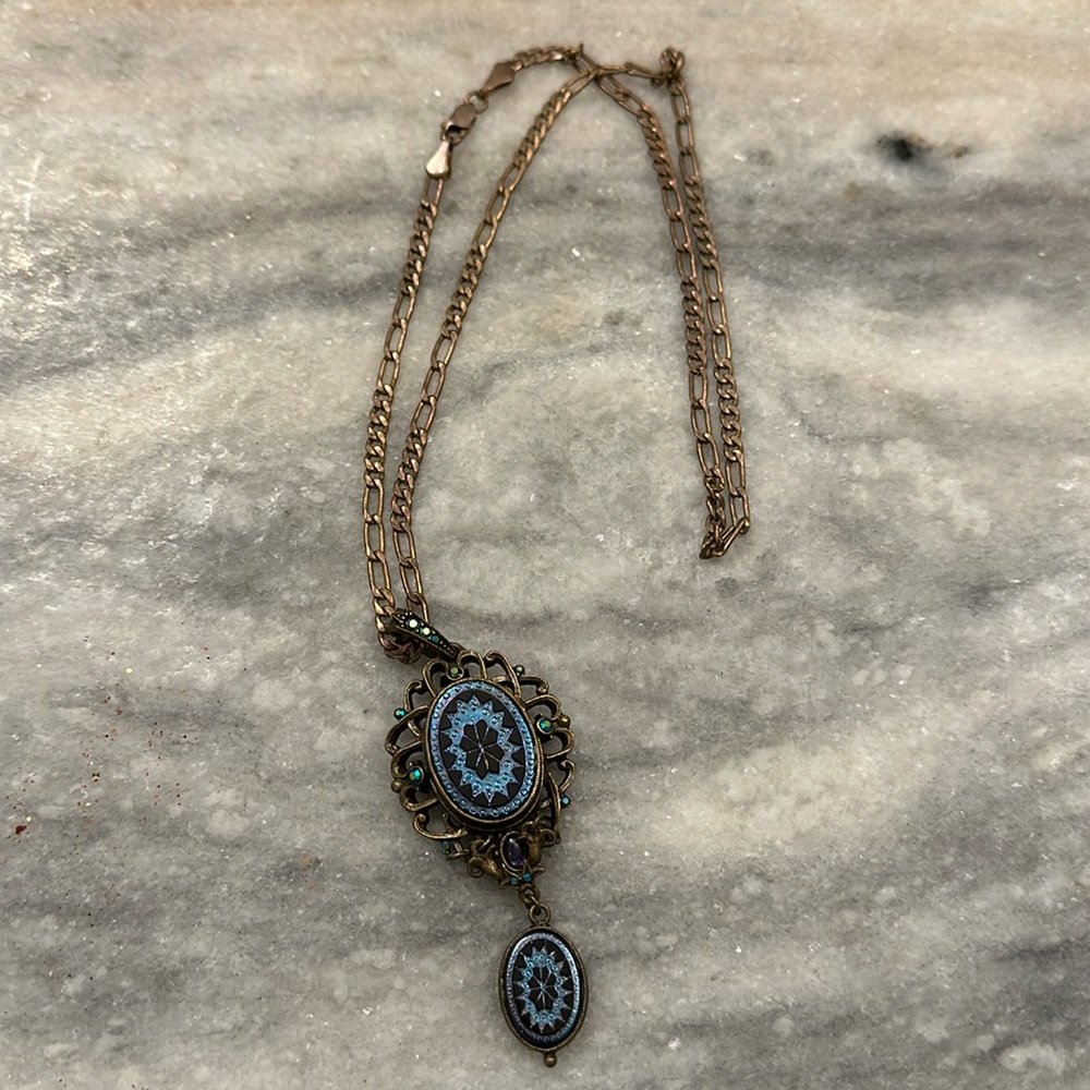 Rose colored gold plated chain link necklace with matching blue crystal pendant